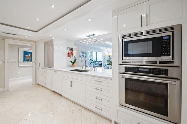 kitchen featuring baseboards, marble finish floor, a sink, white cabinets, and appliances with stainless steel finishes