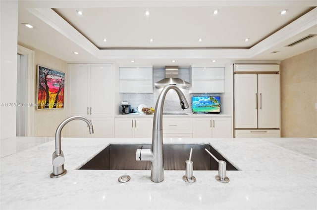 kitchen featuring white cabinets, visible vents, light stone counters, and tasteful backsplash