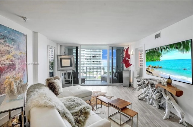 2200 NE 33rd Ave Unit 10F, Fort Lauderdale, FL 33305 - living area featuring visible vents, a wall of windows, and wood finished floors
