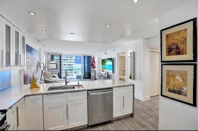 2200 NE 33rd Ave Unit 10F, Fort Lauderdale, FL 33305 - kitchen with a peninsula, dishwasher, a sink, and white cabinetry