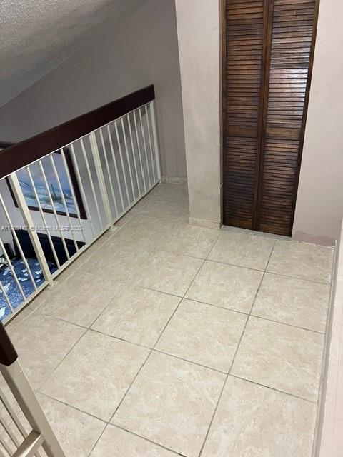 12045 SW 18th St Unit 1-42, Miami, FL 33175 - corridor featuring tile patterned flooring and a textured ceiling