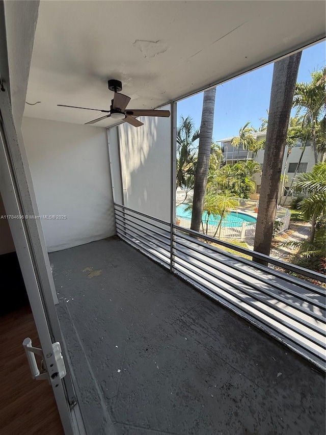 view of patio with an outdoor pool, a ceiling fan, and a balcony
