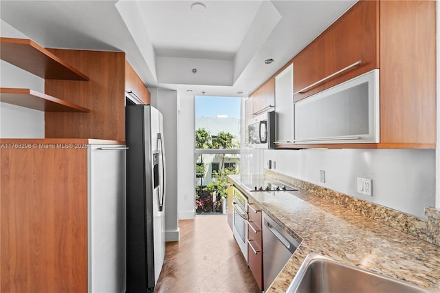 110 Washington Ave Unit 2307, Miami Beach, FL 33139 - kitchen featuring appliances with stainless steel finishes, wood finished floors, modern cabinets, brown cabinetry, and open shelves