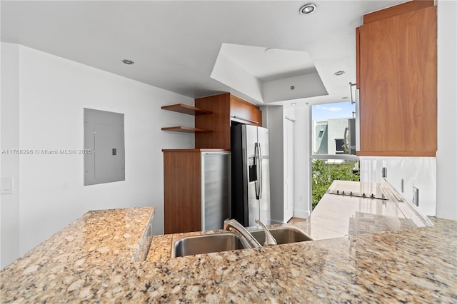 110 Washington Ave Unit 2307, Miami Beach, FL 33139 - kitchen featuring electric panel, stainless steel refrigerator with ice dispenser, open shelves, light stone counters, and brown cabinets