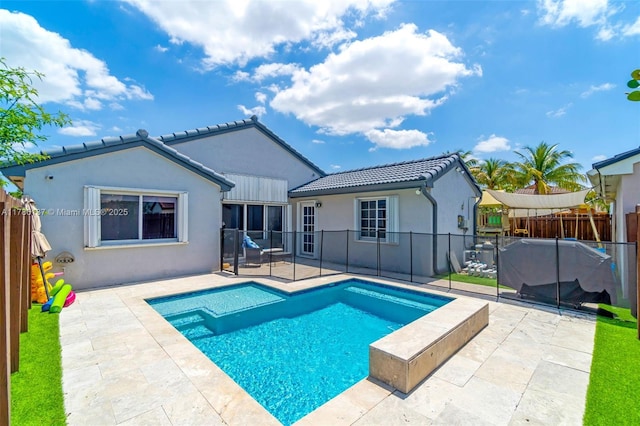 8612 SW 159th Pl, Miami, FL 33193 - back of property featuring a tiled roof, stucco siding, a patio area, and a fenced backyard
