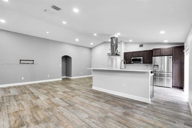 8612 SW 159th Pl, Miami, FL 33193 - kitchen featuring stainless steel appliances, wall chimney exhaust hood, lofted ceiling, arched walkways, and light countertops