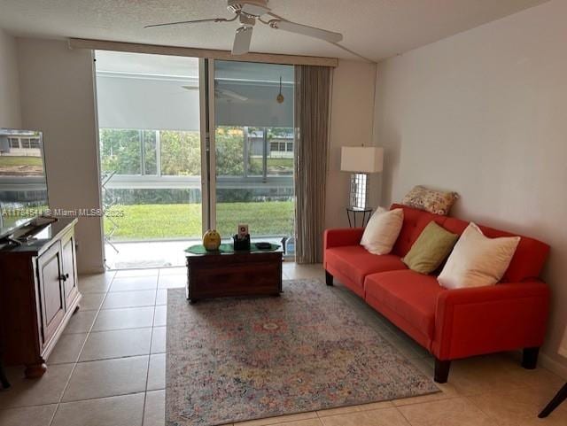tiled living room with a ceiling fan and floor to ceiling windows