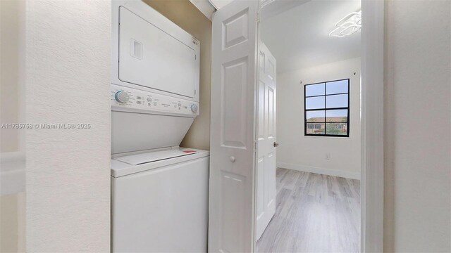 9231 W 32nd Ln, Hialeah, FL 33018 - washroom featuring stacked washer / drying machine and light wood-type flooring