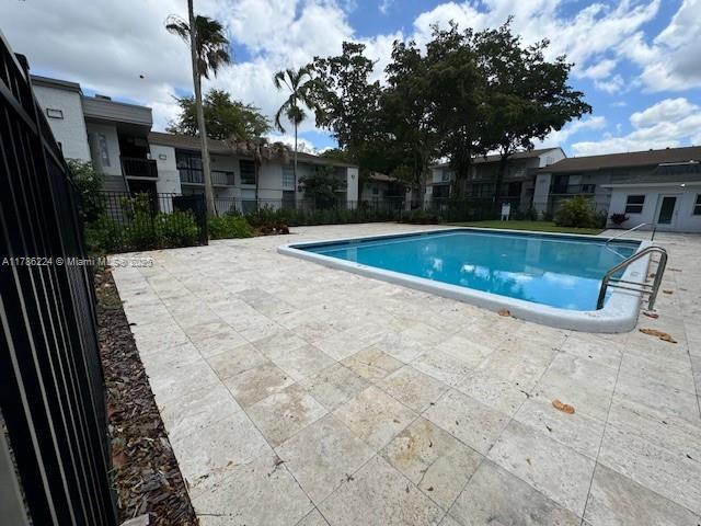 community pool featuring a patio and fence
