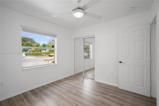 244 NW 179th St, Miami Gardens, FL 33169 - unfurnished bedroom featuring baseboards, wood finished floors, multiple windows, and a closet
