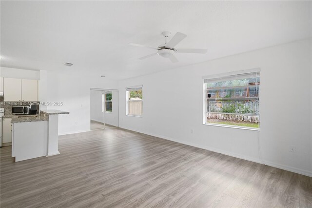 244 NW 179th St, Miami Gardens, FL 33169 - unfurnished living room featuring wood finished floors, visible vents, baseboards, and ceiling fan