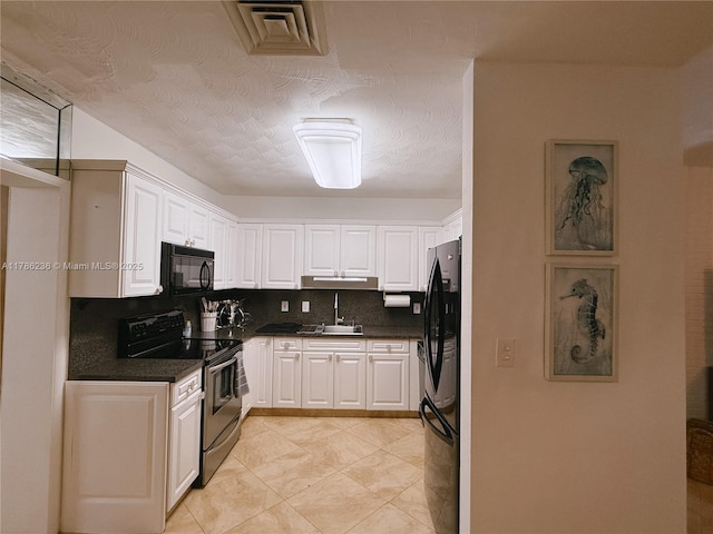 kitchen with visible vents, dark countertops, tasteful backsplash, a sink, and black appliances