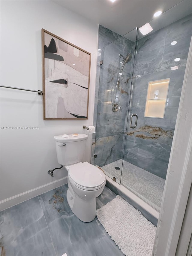 bathroom with toilet, baseboards, a shower stall, and marble finish floor
