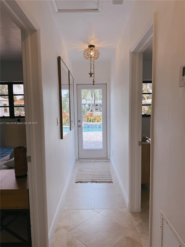 doorway featuring visible vents, baseboards, and light tile patterned floors