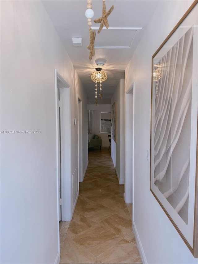 hall featuring baseboards and visible vents