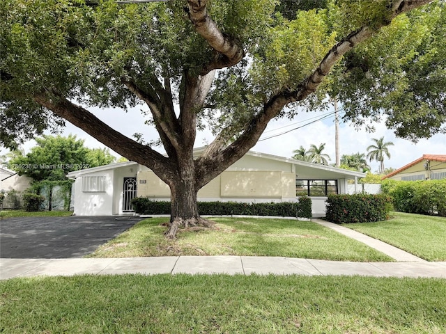 view of front of property featuring a front lawn, aphalt driveway, and stucco siding