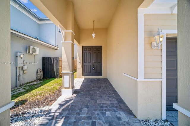 146 NE 36th Ter, Homestead, FL 33033 - view of exterior entry with stucco siding, fence, and an AC wall unit