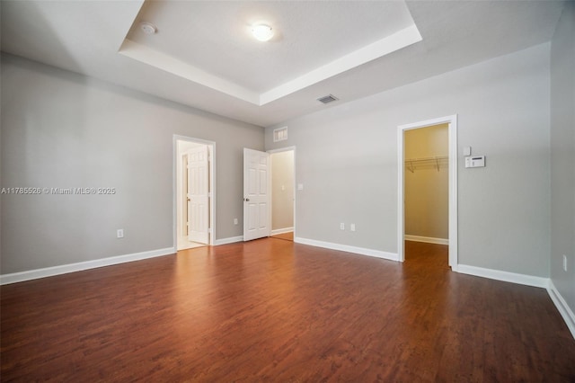146 NE 36th Ter, Homestead, FL 33033 - spare room with visible vents, baseboards, a tray ceiling, and dark wood finished floors