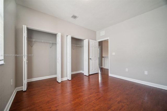 146 NE 36th Ter, Homestead, FL 33033 - unfurnished bedroom featuring two closets, baseboards, wood finished floors, and visible vents