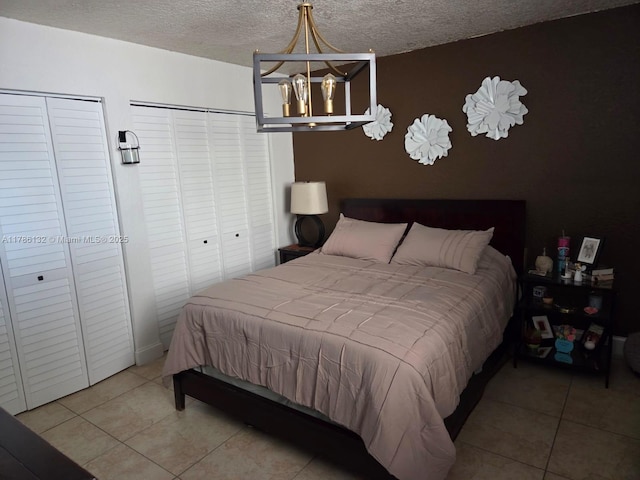 9411 SW 4th St Unit 203, Miami, FL 33174 - tiled bedroom with a chandelier, a textured ceiling, and two closets