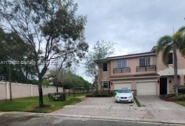 traditional-style house with driveway, fence, and a garage