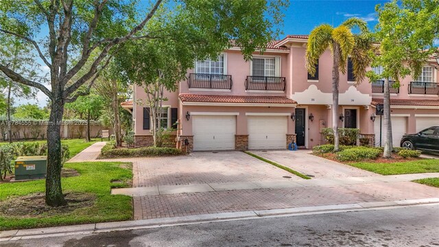 294 Las Brisas Cir, Sunrise, FL 33326 - view of front of property with a balcony, stucco siding, a garage, driveway, and a tiled roof