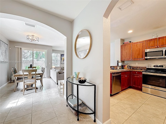 294 Las Brisas Cir, Sunrise, FL 33326 - kitchen featuring stainless steel appliances, arched walkways, light tile patterned floors, and recessed lighting