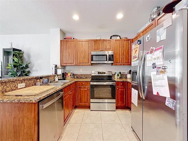 294 Las Brisas Cir, Sunrise, FL 33326 - kitchen featuring appliances with stainless steel finishes, a peninsula, a sink, light tile patterned floors, and light stone countertops