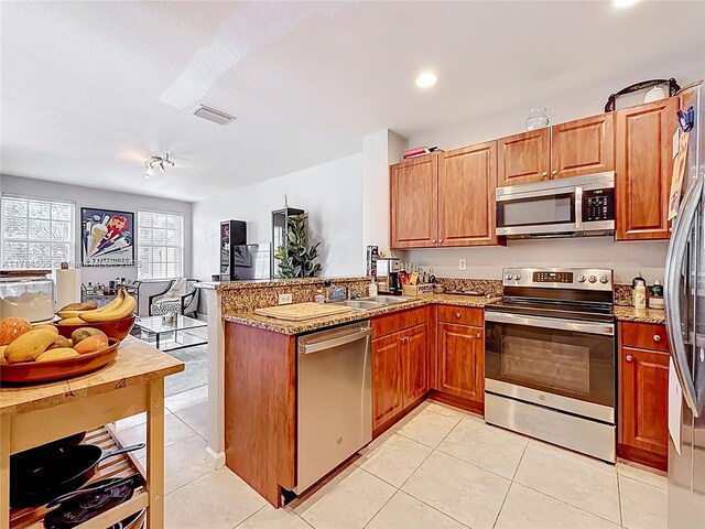 294 Las Brisas Cir, Sunrise, FL 33326 - kitchen with stainless steel appliances, a peninsula, open floor plan, light tile patterned flooring, and light stone countertops