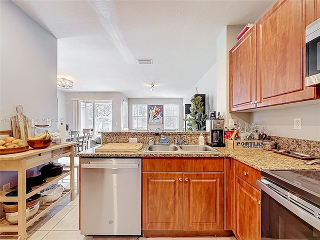 294 Las Brisas Cir, Sunrise, FL 33326 - kitchen with stainless steel dishwasher, a sink, a peninsula, open floor plan, and light tile patterned floors