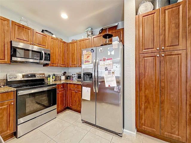 294 Las Brisas Cir, Sunrise, FL 33326 - kitchen with appliances with stainless steel finishes, light tile patterned floors, brown cabinets, and light stone countertops