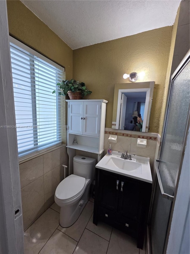 12585 NE Miami Ct, North Miami, FL 33161 - bathroom featuring vanity, toilet, a textured ceiling, tile patterned floors, and tile walls