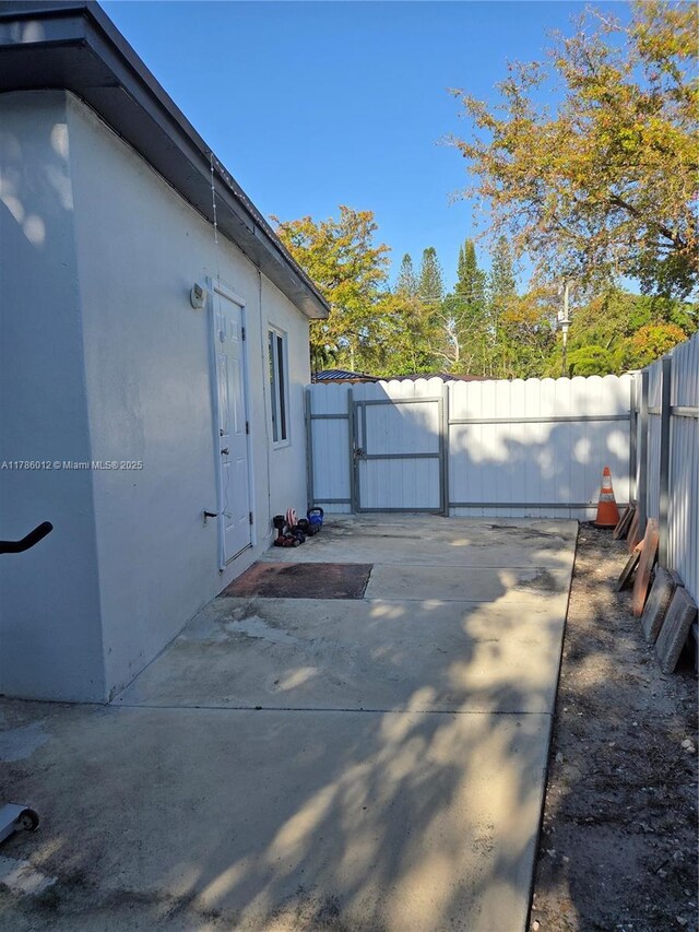 12585 NE Miami Ct, North Miami, FL 33161 - view of side of property with a patio, a gate, fence, and stucco siding