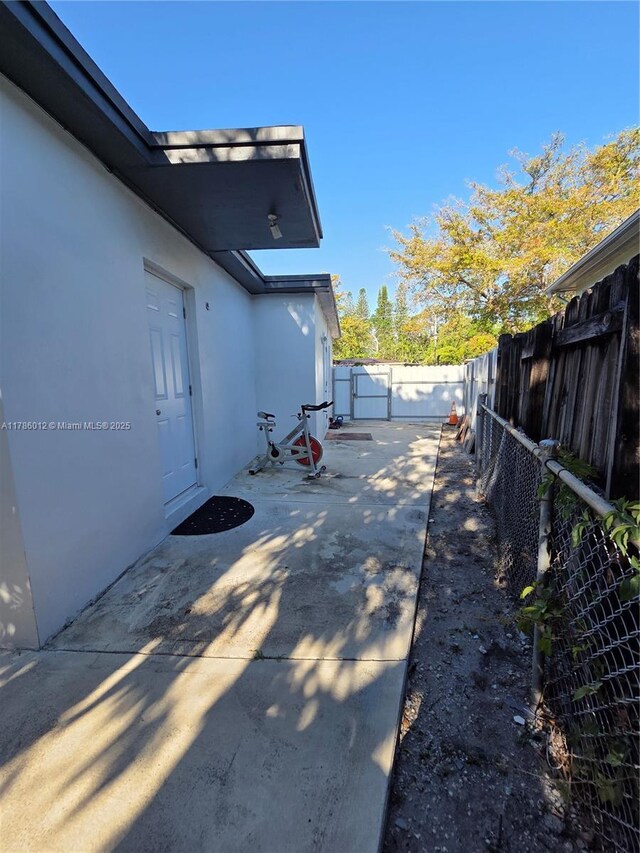 12585 NE Miami Ct, North Miami, FL 33161 - view of side of property with a fenced backyard, a patio area, and stucco siding