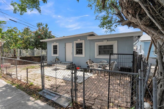 view of front of house featuring a patio area, a gate, a fenced front yard, and stucco siding