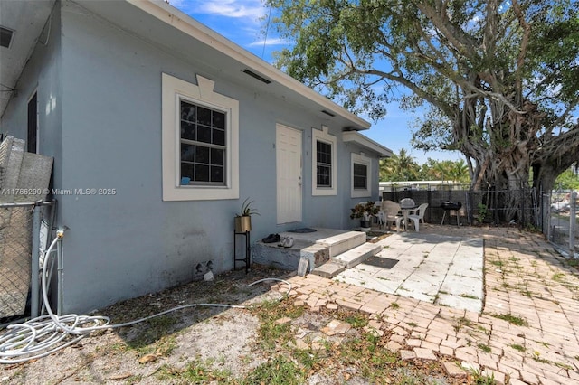 rear view of house with a patio, a fenced backyard, and stucco siding