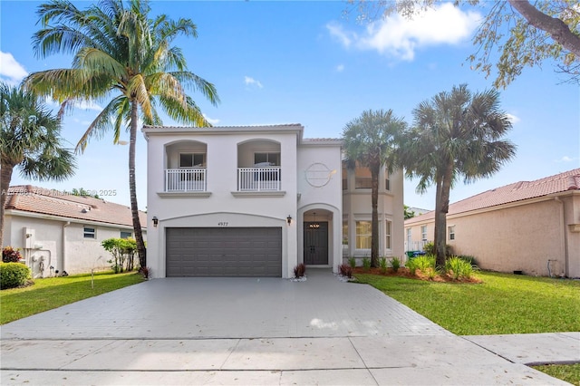 mediterranean / spanish-style house with an attached garage, a front yard, driveway, and a balcony