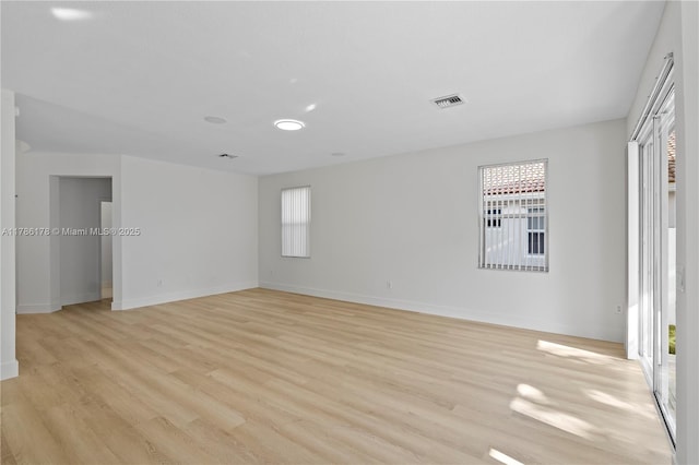interior space with baseboards, visible vents, a wealth of natural light, and light wood finished floors