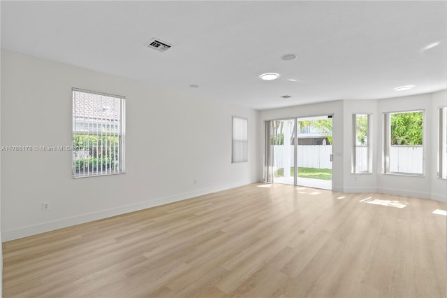 spare room featuring baseboards, visible vents, and light wood-style flooring