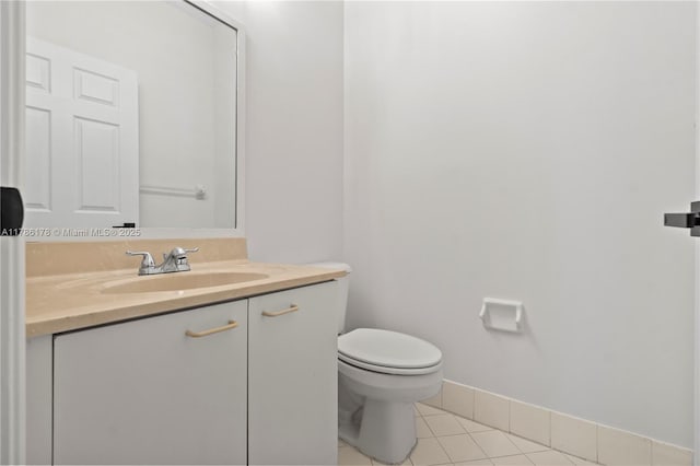 bathroom featuring vanity, tile patterned flooring, baseboards, and toilet
