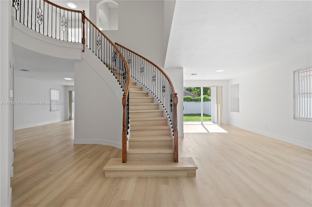 staircase featuring baseboards and wood finished floors