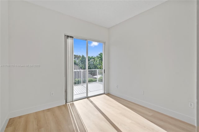 spare room with light wood-style floors and baseboards