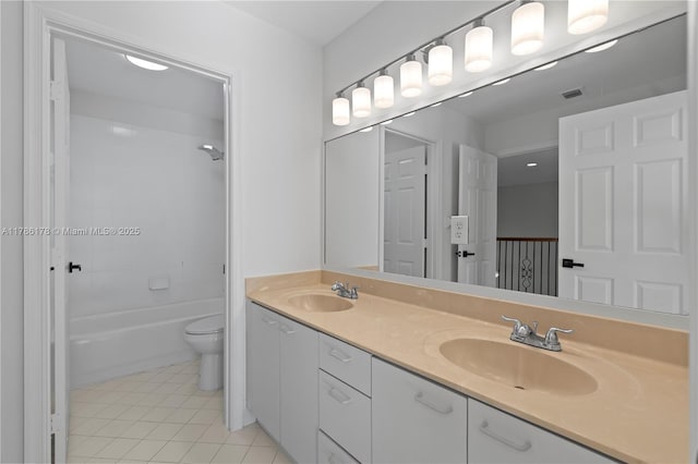 full bath featuring double vanity, a sink, tile patterned floors, and toilet
