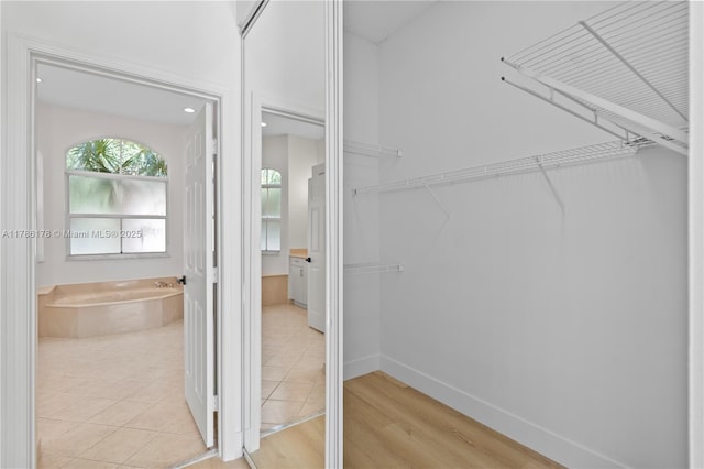 walk in closet with light tile patterned floors
