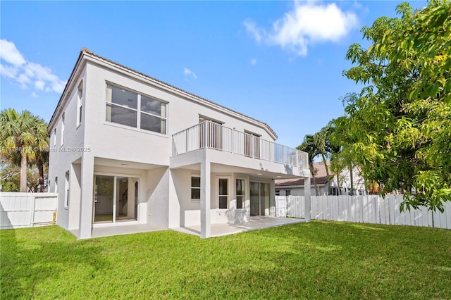 rear view of property featuring a patio, fence, a balcony, and stucco siding