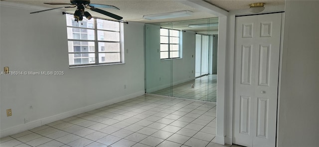 14195 SW 87th St Unit B306, Miami, FL 33183 - spare room featuring a ceiling fan, a textured ceiling, light tile patterned floors, and baseboards