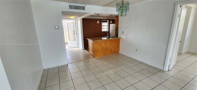 14195 SW 87th St Unit B306, Miami, FL 33183 - kitchen featuring light tile patterned flooring, freestanding refrigerator, brown cabinetry, baseboards, and a textured ceiling