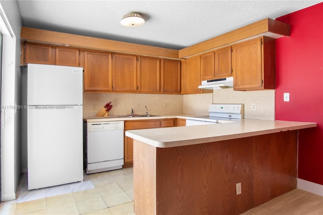 2572 Lakeview Ct, Cooper City, FL 33026 - kitchen featuring a sink, light countertops, a peninsula, under cabinet range hood, and white appliances