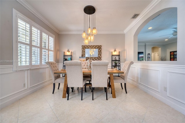 1454 Newhaven Point Ln, West Palm Beach, FL 33411 - dining area featuring a decorative wall, crown molding, light tile patterned flooring, a chandelier, and arched walkways