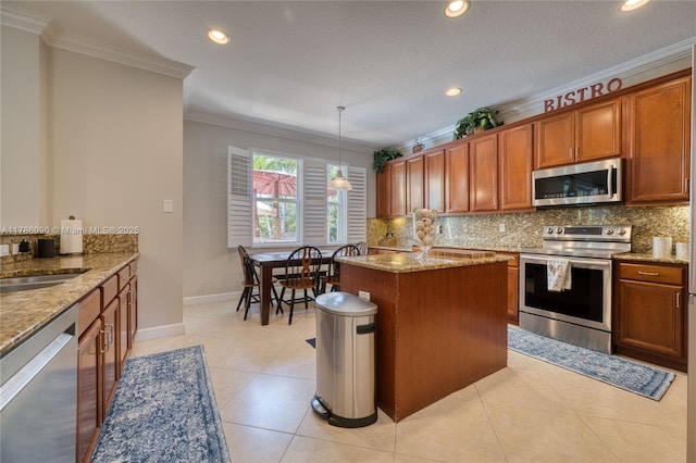 1454 Newhaven Point Ln, West Palm Beach, FL 33411 - kitchen featuring appliances with stainless steel finishes, crown molding, backsplash, brown cabinetry, and light stone counters